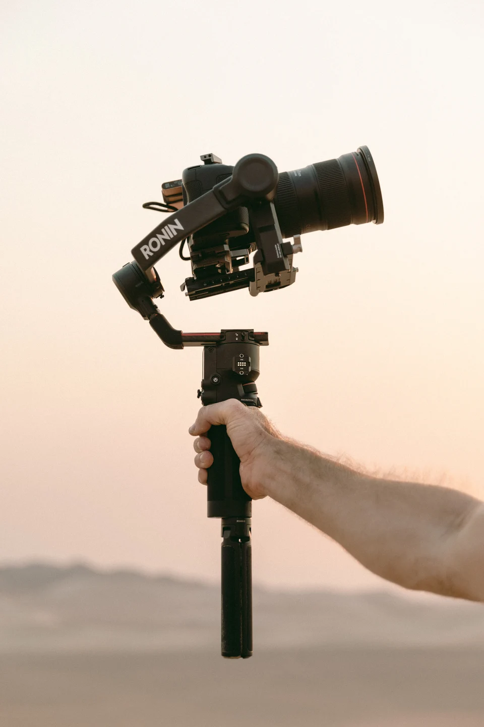 Hand holding stabilized camera at dusk