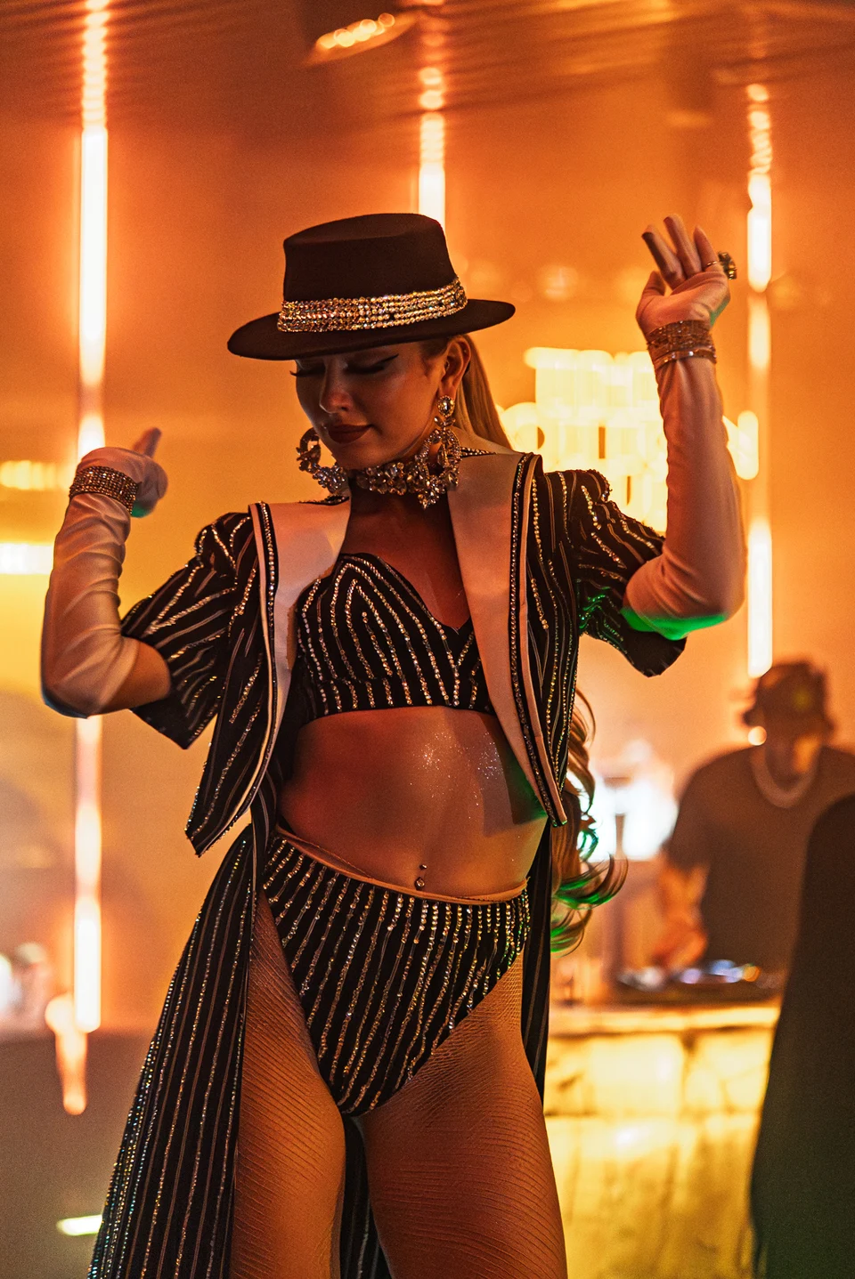 Hat wearing performer in amber light