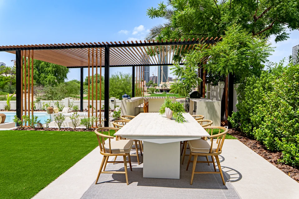 Outdoor dining table beneath garden pergola
