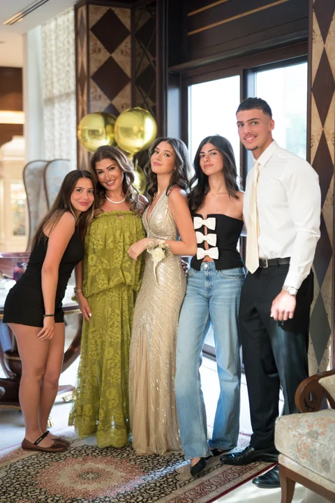 Wedding guests posing near gold balloons