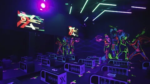 An empty fitness studio with neon lights and vivid wall murals.