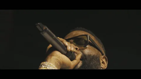 A close-up of a stage performer holding a microphone.